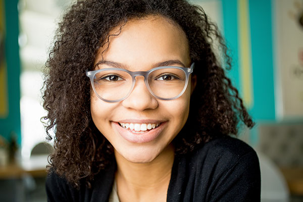 young girl wearing glasses smiling